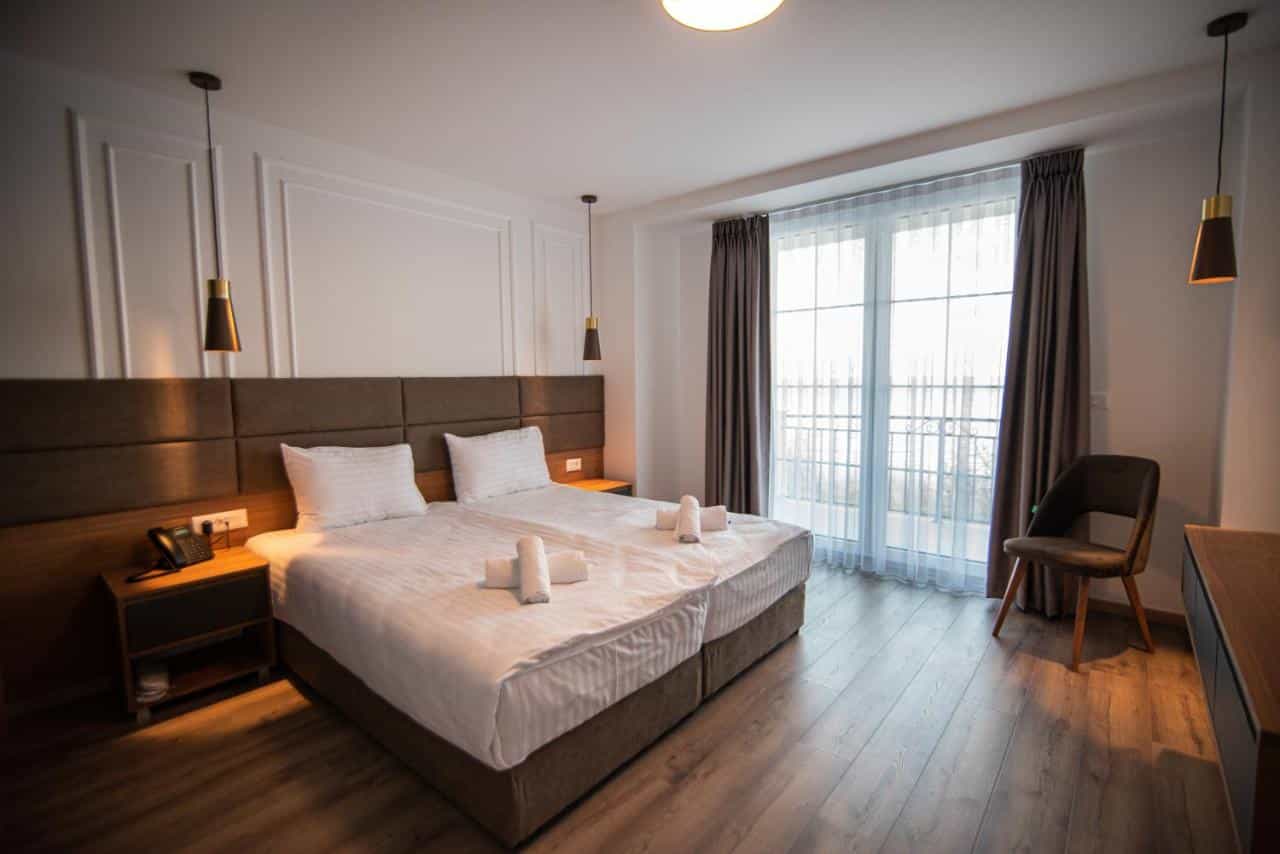 Twin beds with white linens in a modern hotel room at Dishli Hotel & Spa Struga.