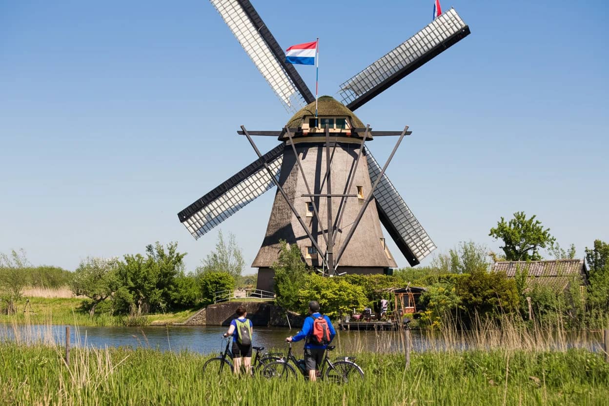 Couple with bikes watching the windmill at Kinderdijik