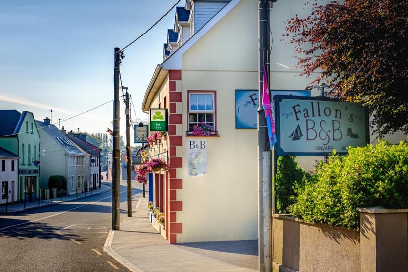 Fallon's B&B sign on cream building corner next to quiet street in Kinvara.