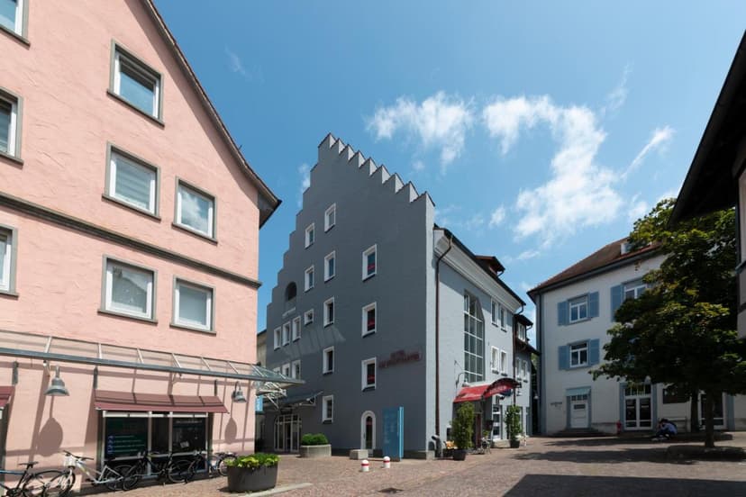 Hotel am Stadtgarten in Radolfzell-am-Bodensee with historic buildings under blue sky.