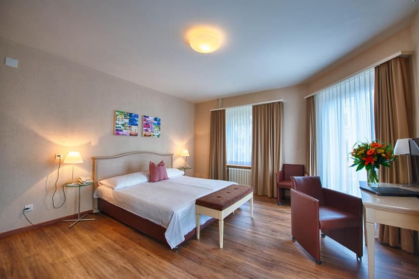 Hotel Neufeld room in Zurich with wood floors, double bed, and bright window light.