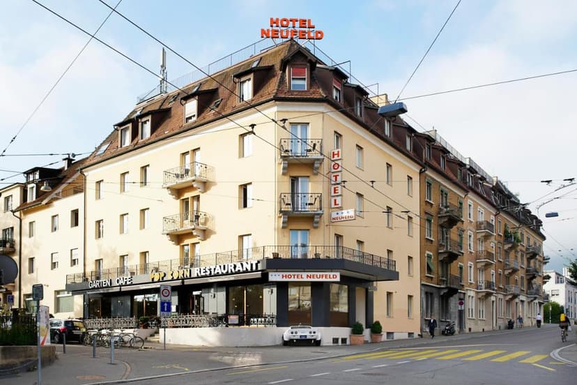 Hotel Neufeld building with Garten Cafe and Pop Corn Restaurant on a street in Zurich.