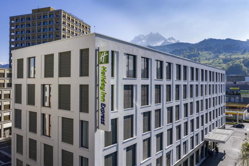 Holiday Inn Express building with snow-capped mountains in the background in Lucerne.