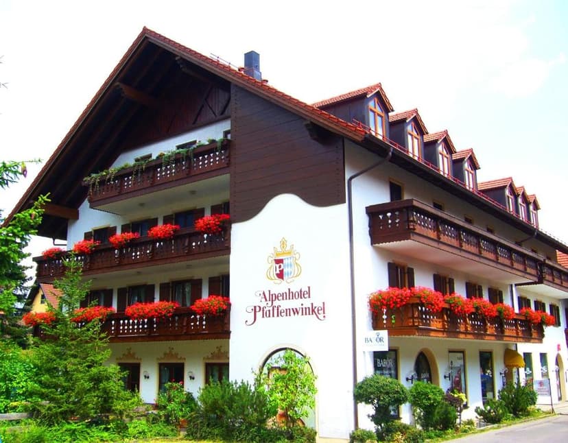 Alpenhotel Pfaffenwinkel building with wooden balconies and red geraniums in Schongau.