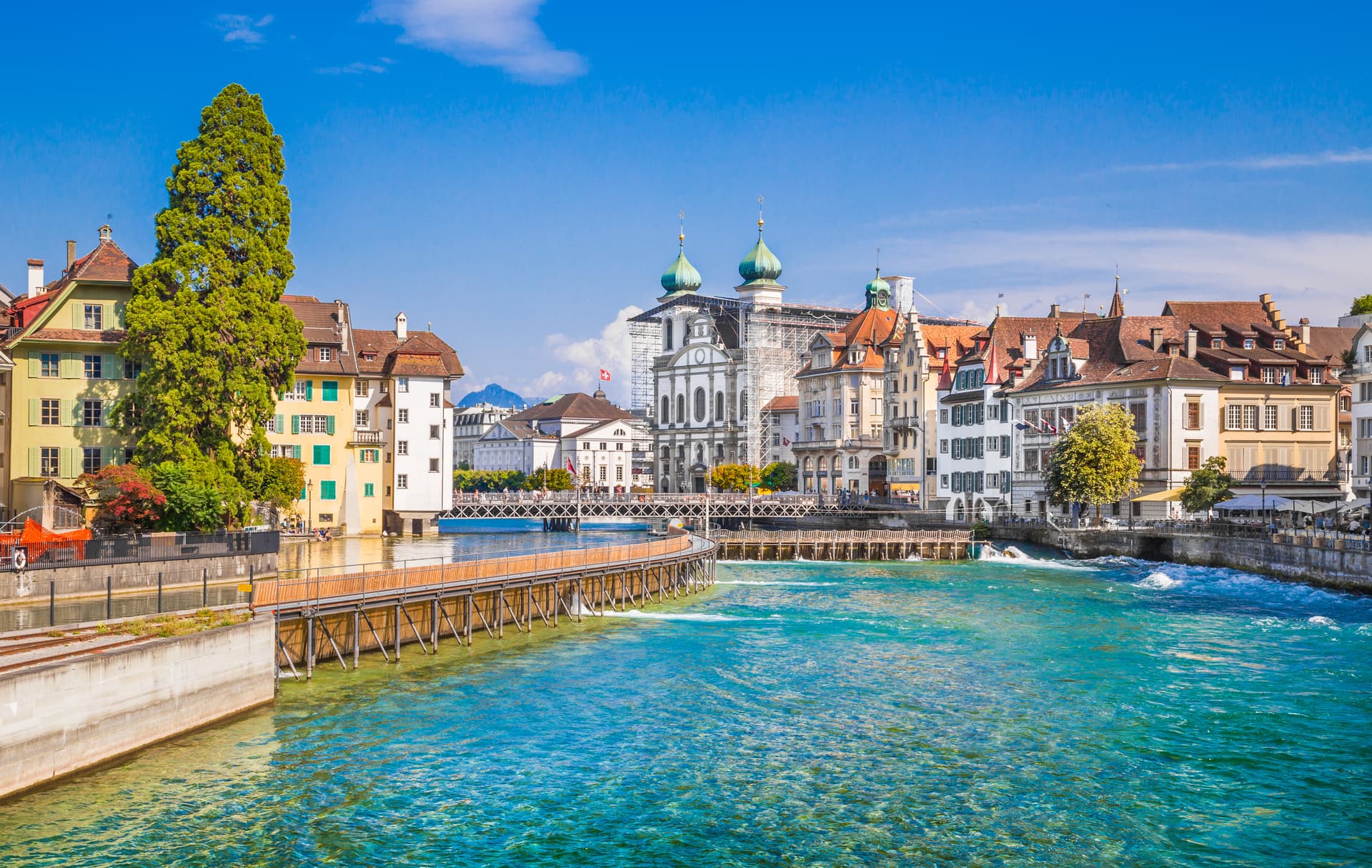 Historic town of Lucerne in summer with turquoise river and historic buildings.