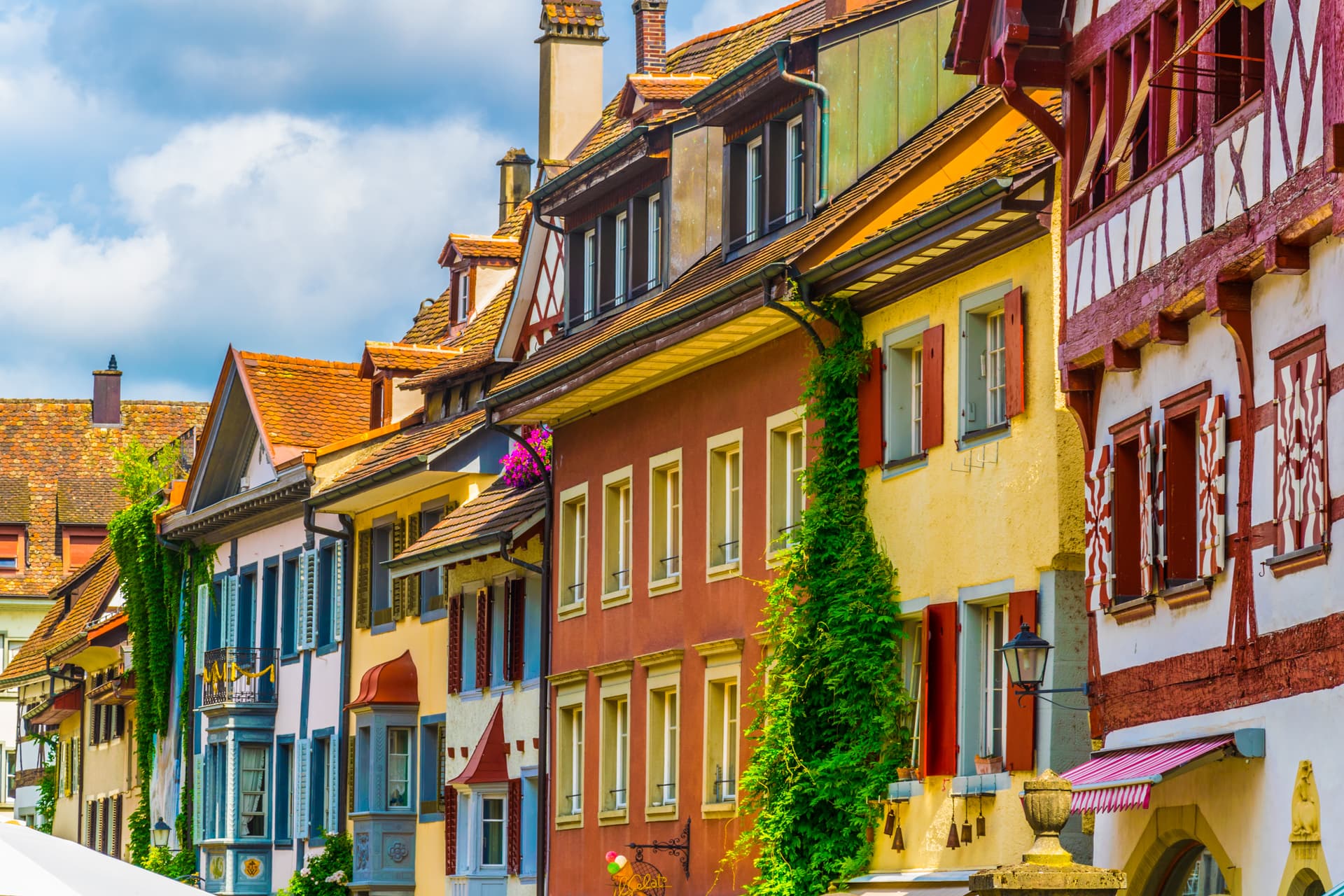 Colorful half-timbered houses with bright shutters in Stein am Rhein under a blue sky.