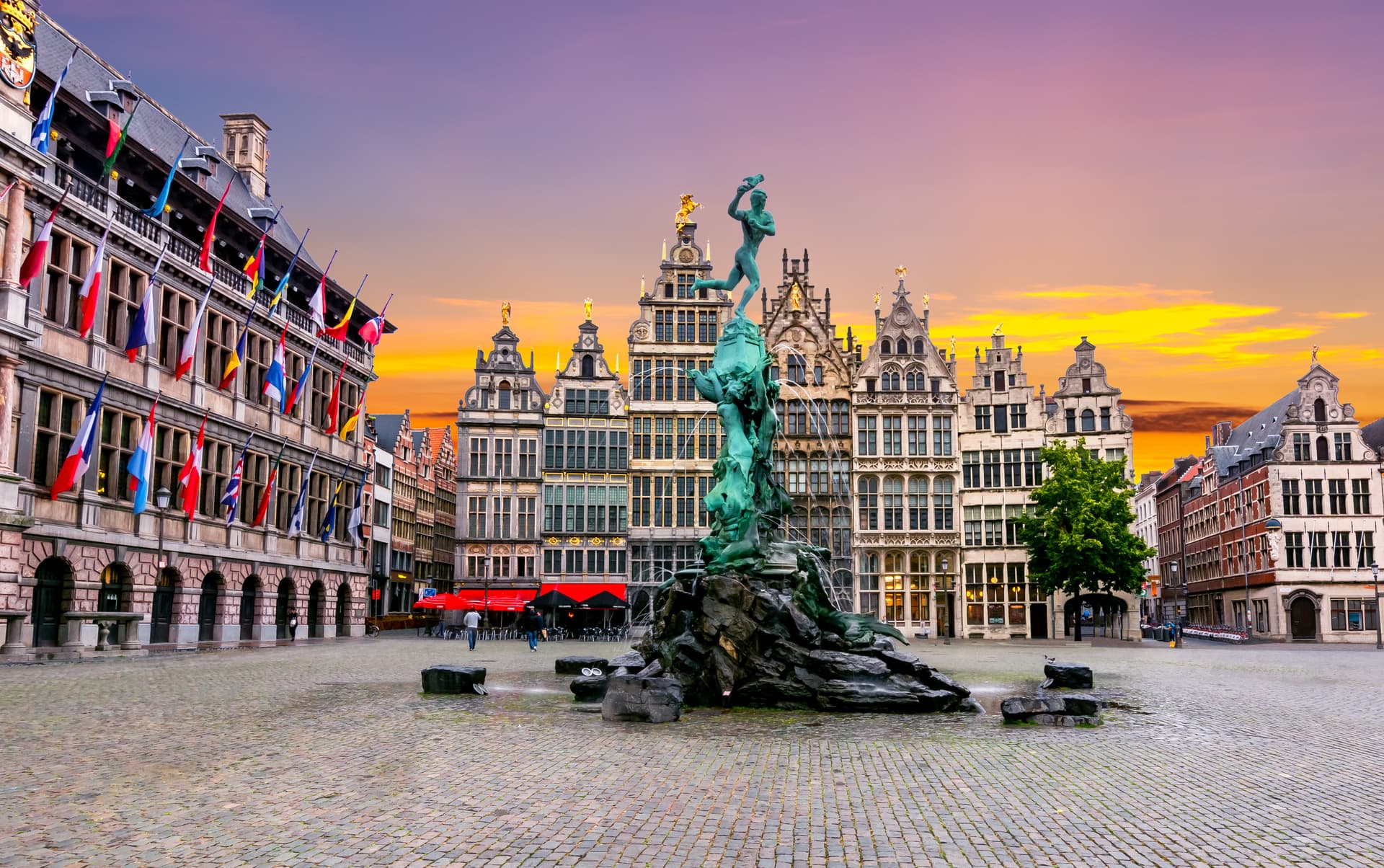 Brabo Fountain in Grote Markt square with guild houses at sunset, Antwerp, Belgium.