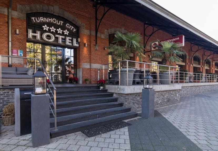 Entrance steps to Turnhout City Best Western Hotel with brick facade and outdoor seating.