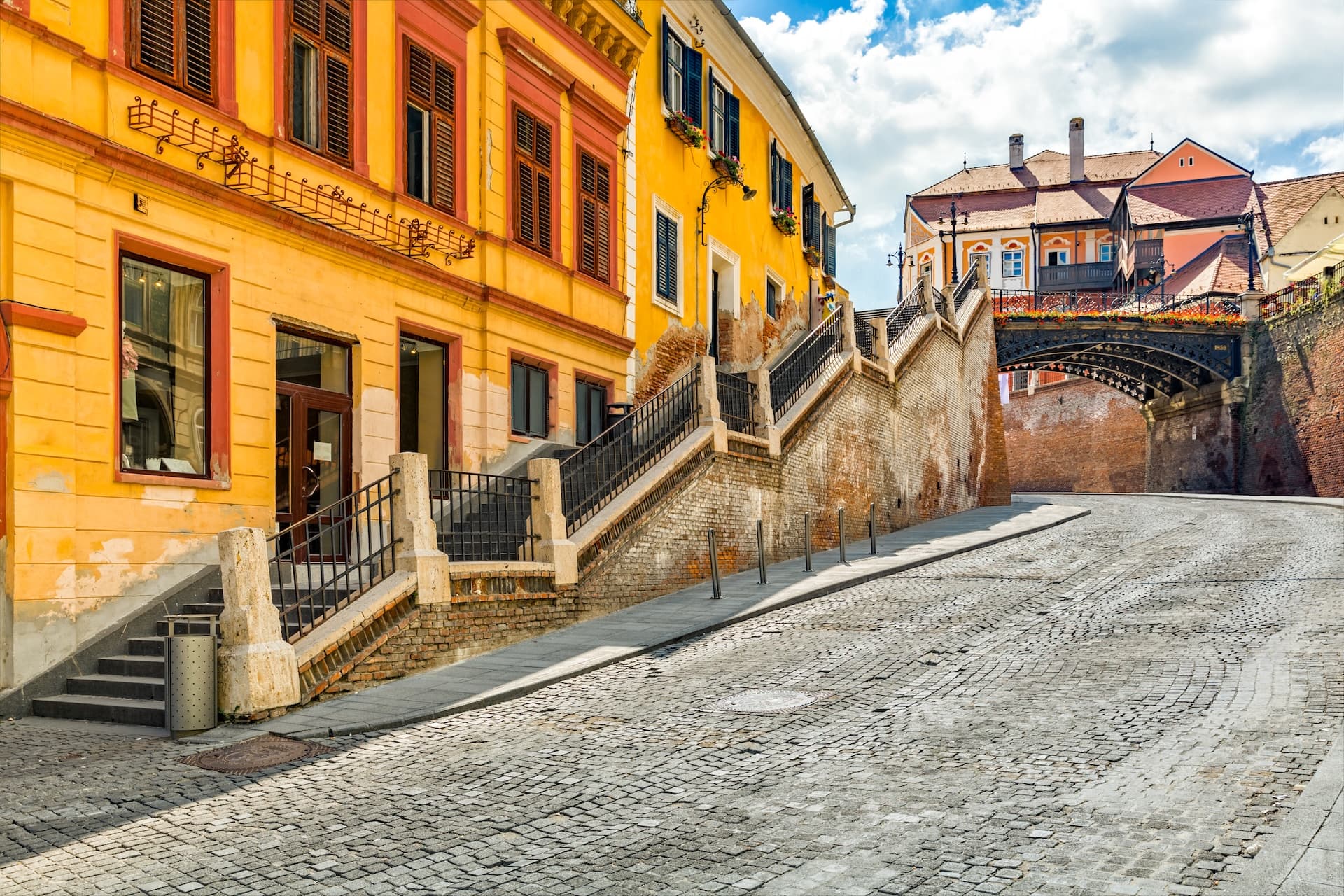 Cobblestone street leading uphill toward the Bridge of Lies in Sibiu, Romania.