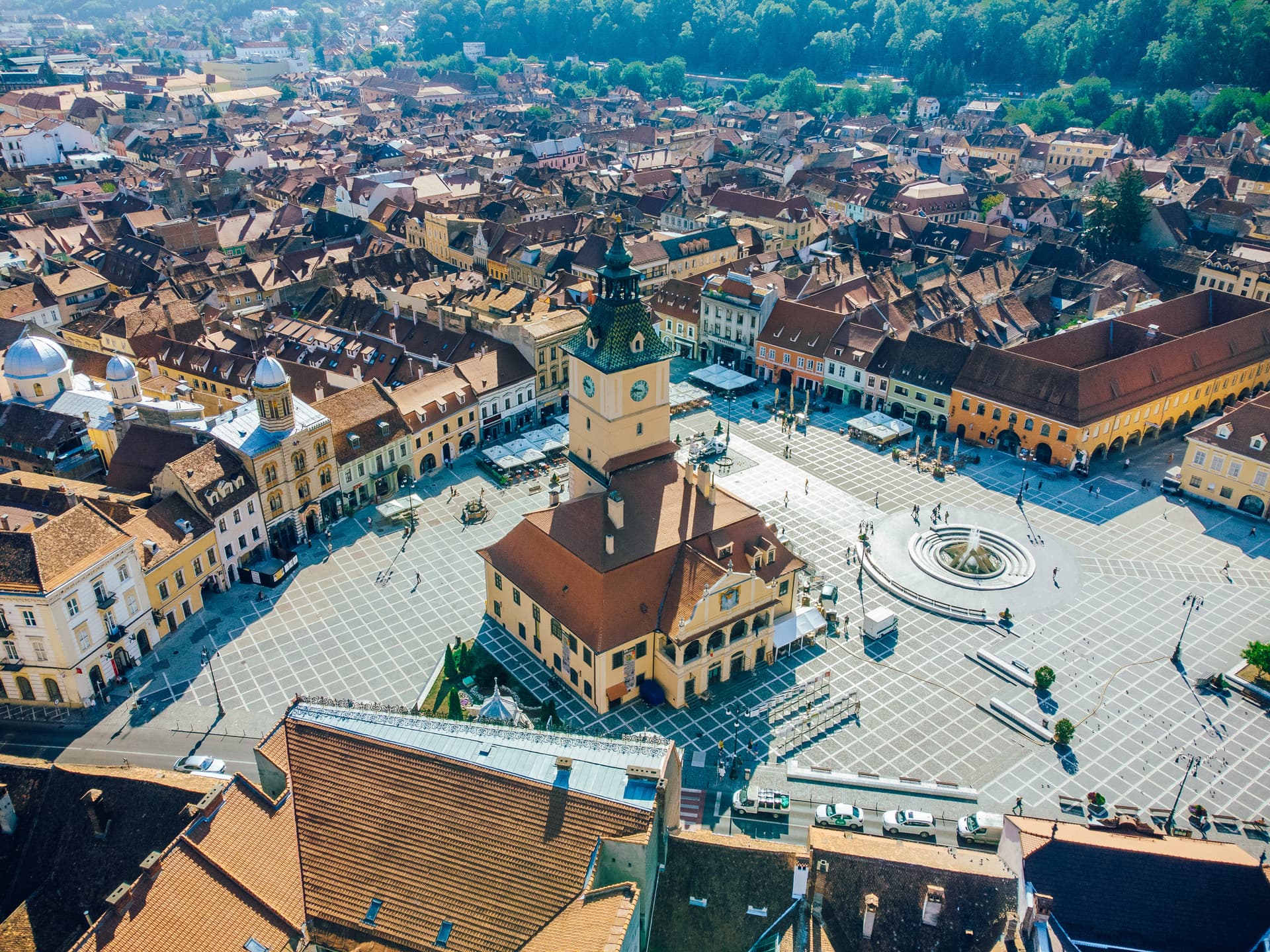 Aerial view of Brasov Square, Romania, featuring the Council House tower and surrounding historic buildings.