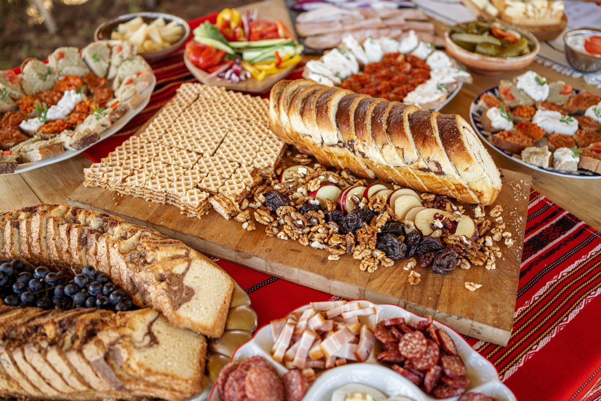 Transylvanian cuisine spread with bread, wafers, nuts, dried fruit, meats, and appetizers.