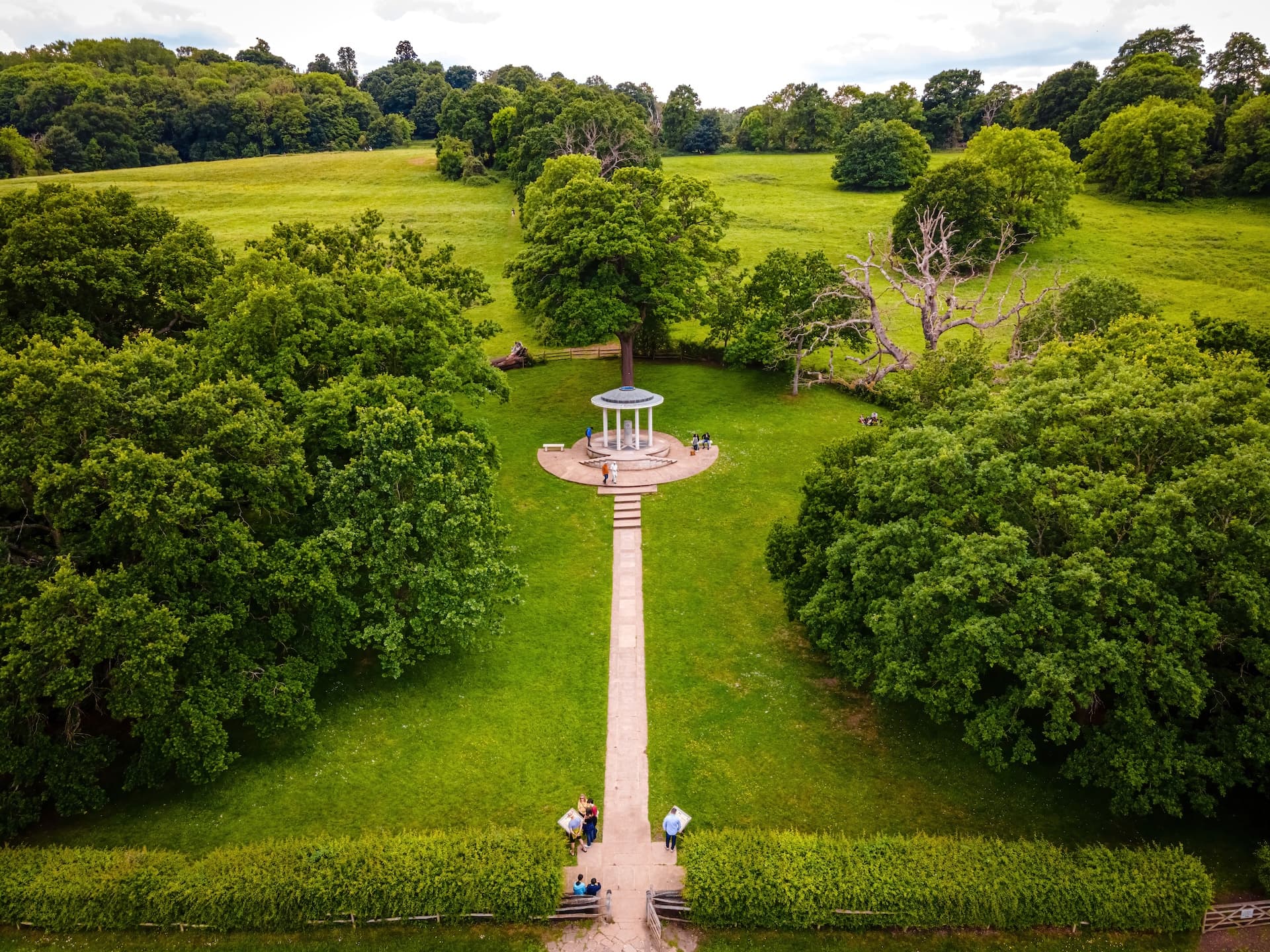 Gazebo on path in green parkland with dense trees, Runnymede.
