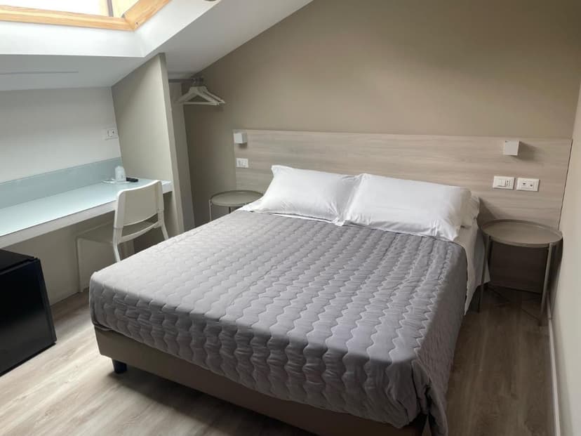 Hotel Principe room with double bed, skylight, and built-in desk area