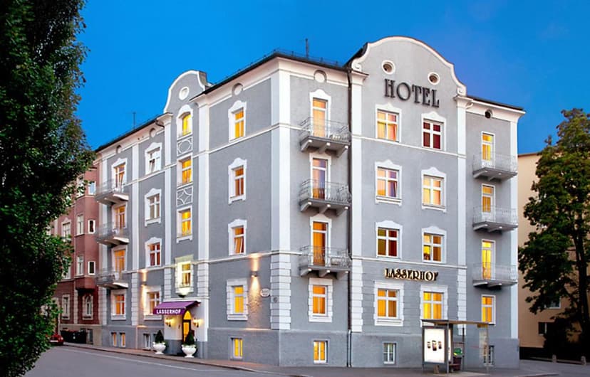 Hotel Lasserhof building exterior at dusk with illuminated windows and street signage.