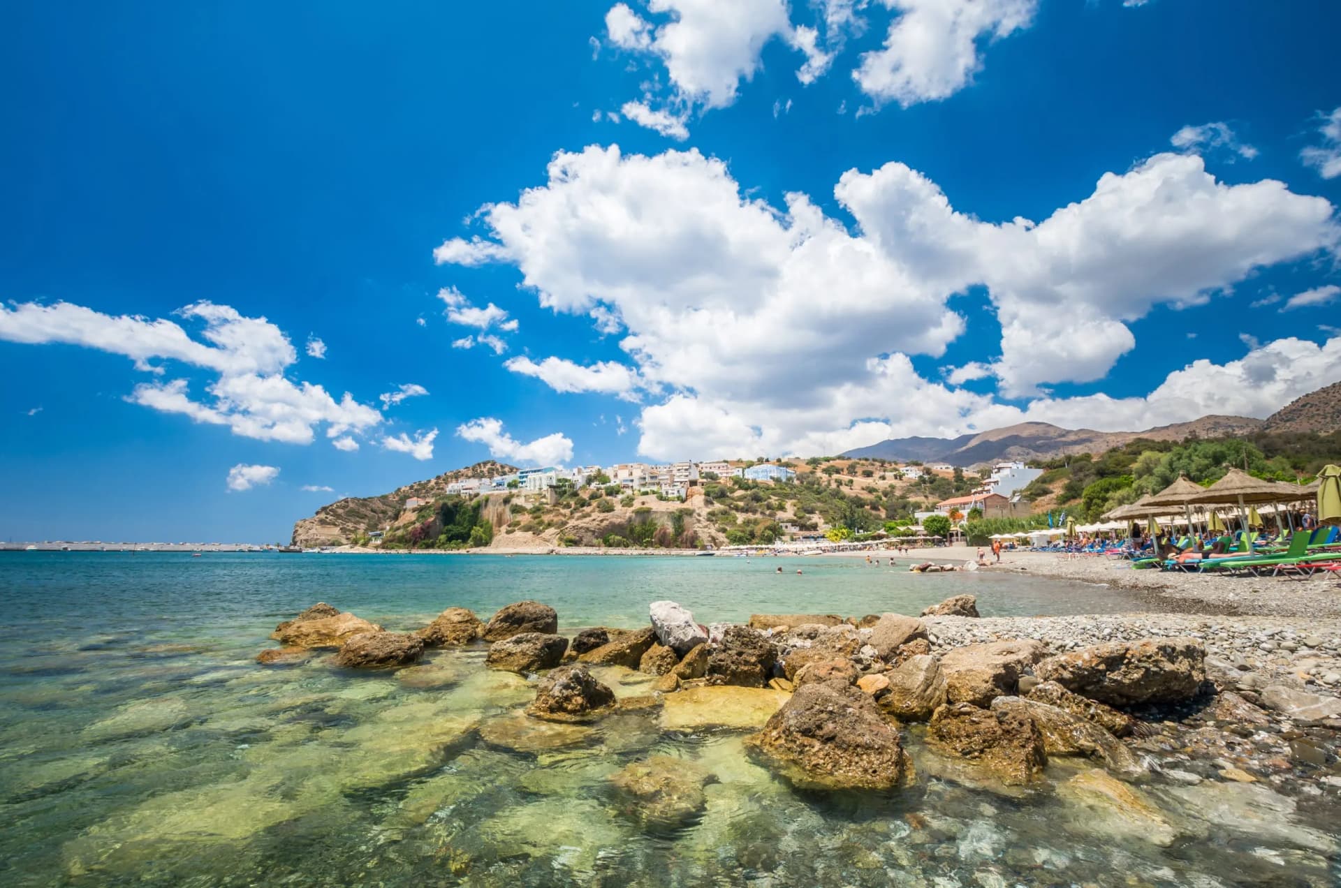 Agia Galini Beach in Crete island, Greece. Tourists relax and bath in crystal clear water of Agia Galini Beach.