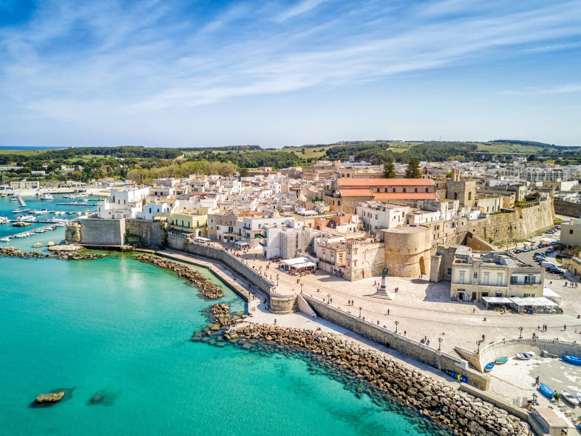 Otranto with Aragonese Castle overlooking turquoise water and harbor in Apulia, Italy.