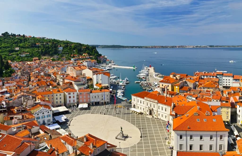 Coastal town with terracotta roofs, central square, and harbor on the Adriatic Sea.