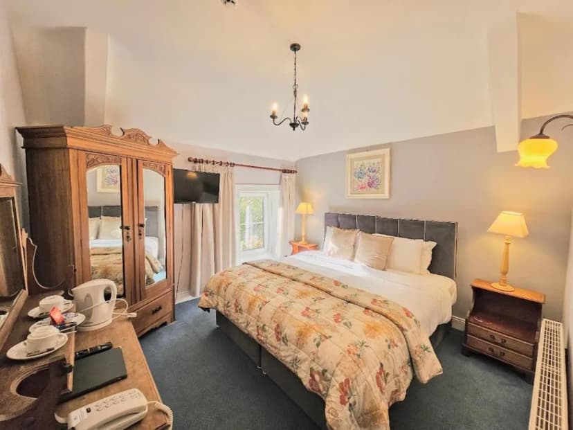 Bedroom in The Glenbeigh Hotel with antique wooden wardrobe and floral quilt