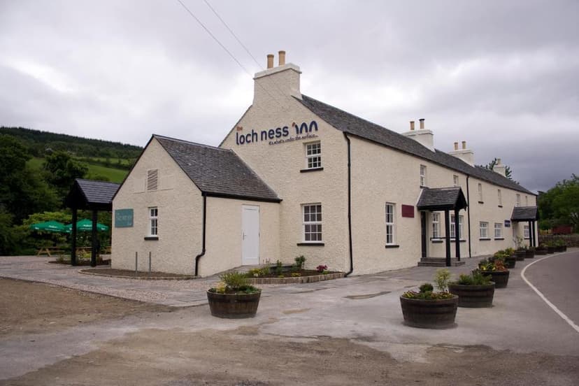 The Loch Ness Inn building with white stucco exterior and dark roof under a cloudy sky.