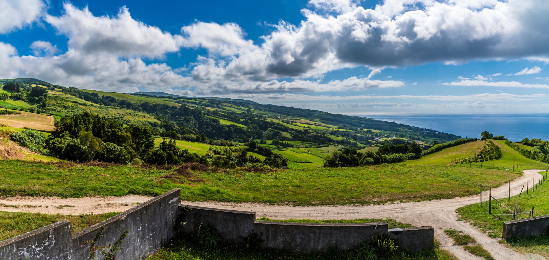 Lush green rolling hills meeting the blue Atlantic Ocean south of São Miguel, Azores.