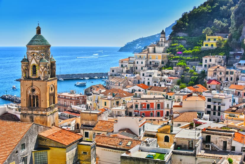 Colorful buildings climb a steep hillside overlooking the blue sea in Town of Amalfi.