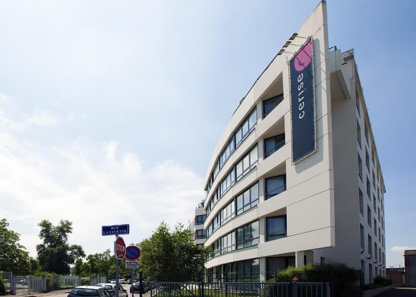 Modern white hotel building with Cerise banner on Rue Lafayette under a bright blue sky.