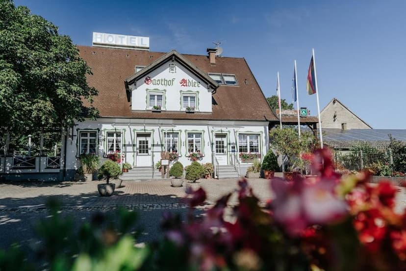 Gasthof Adler hotel building with white facade and brown roof under blue sky in Breisach