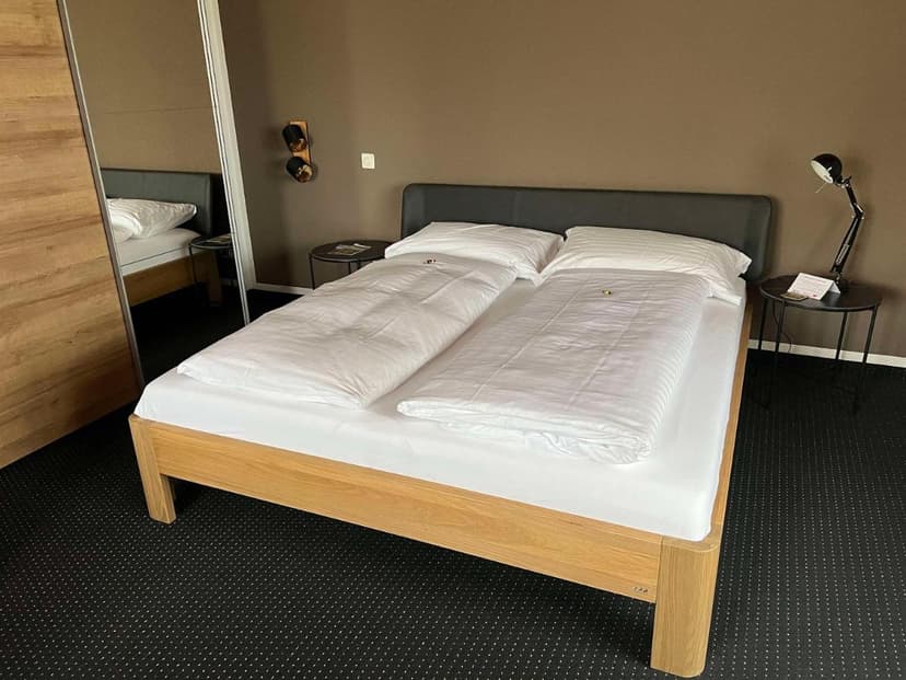 Double bed with white linens in a hotel room at Best Western Hotel Rebstock.