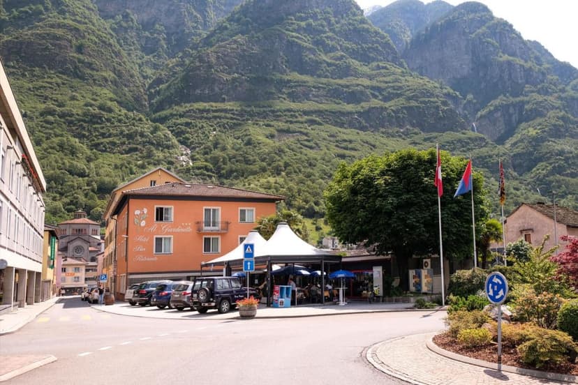 Hotel Bar Ristorante Al Giardinetto in Biasca against steep, green mountains.
