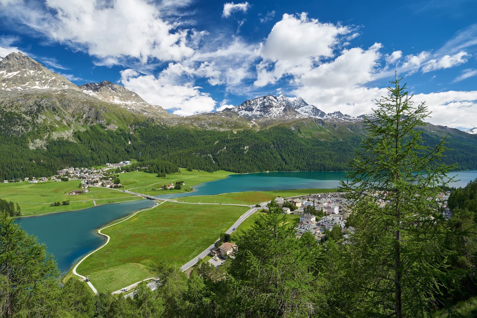 Panoramablick auf Silvaplana, Lej da Champfèr, Silvaplanersee, Surlej und Corvatsch mit Bergen und blauem Himmel.