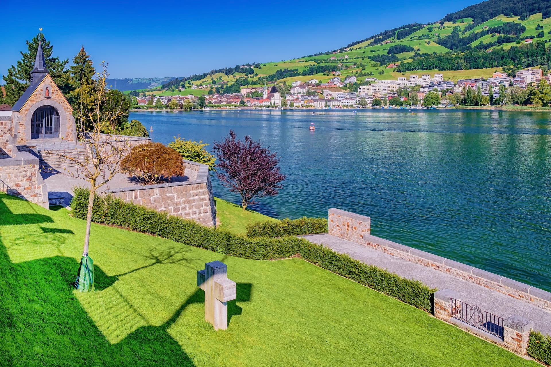 Astrid Chapel overlooking Lake Lucerne with Küssnacht town and green hills.