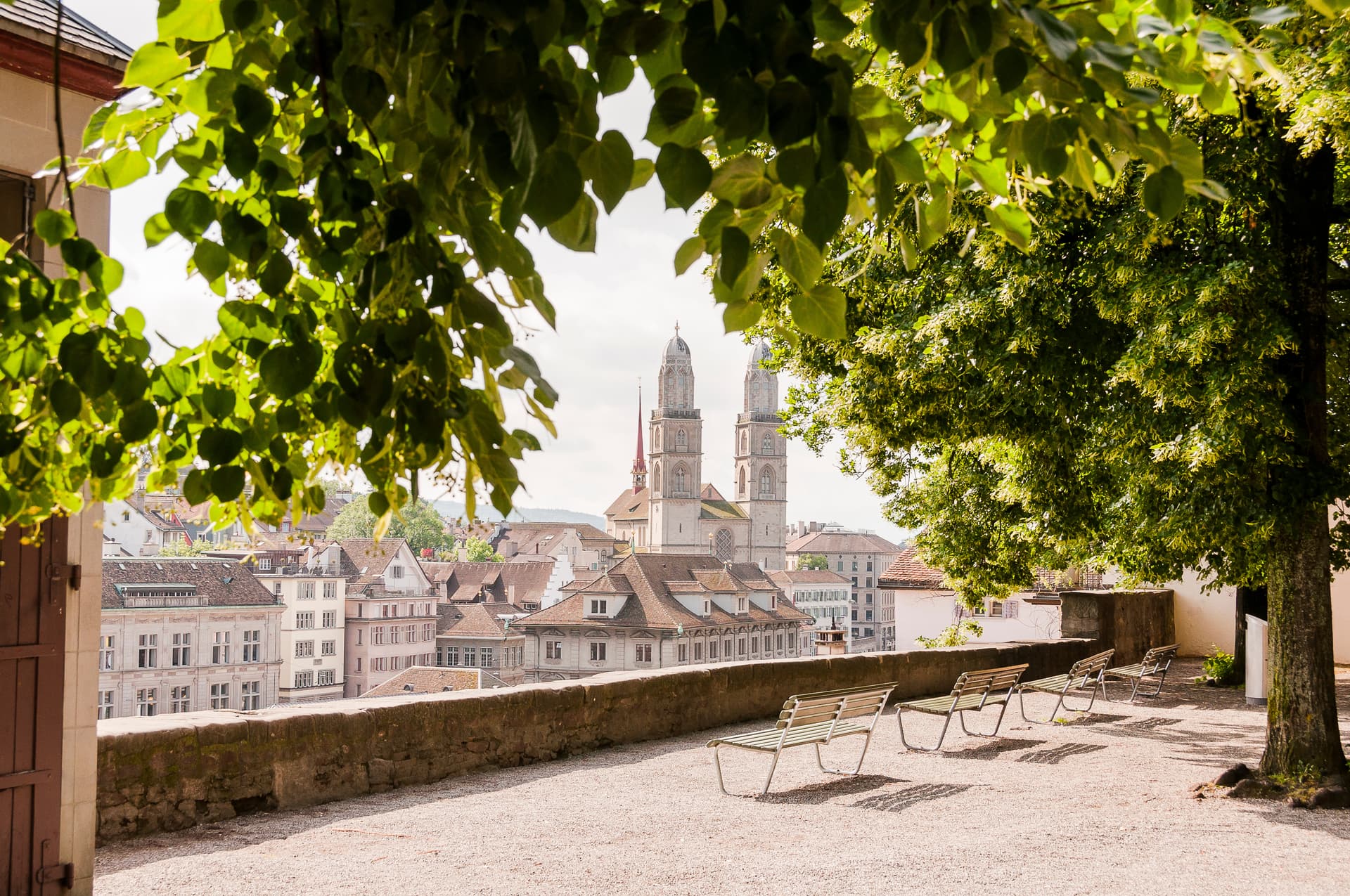View of Grossmünster church from Lindenhof viewpoint over Zurich Altstadt roofs in summer.