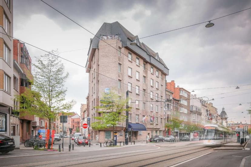 Best Western hotel on city street with moving tram under cloudy sky