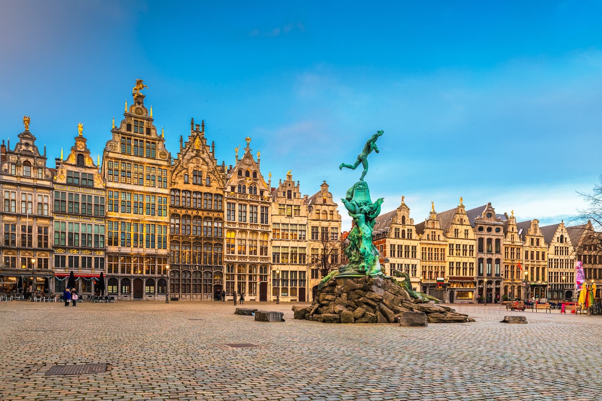 Brabo Fountain in cobblestone Grote Markt square with historic guildhalls, Antwerp.
