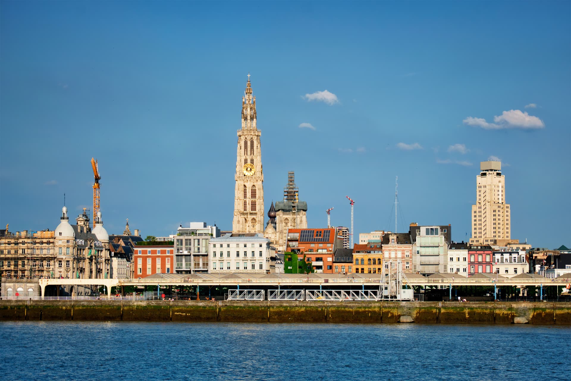 City skyline with tall cathedral tower viewed across the Scheldt River, Antwerp, Belgium.