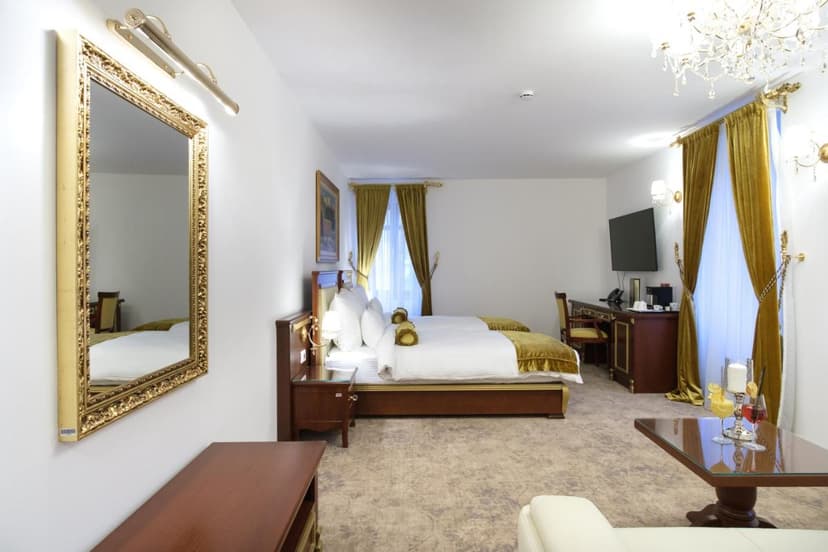 Hotel room with twin beds, gold trim, large mirror, and velvet curtains in Trebinje.