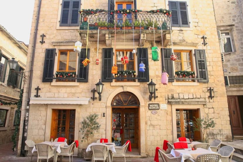 Hotel Marija in Kotor decorated for Christmas with outdoor cafe seating on stone street.