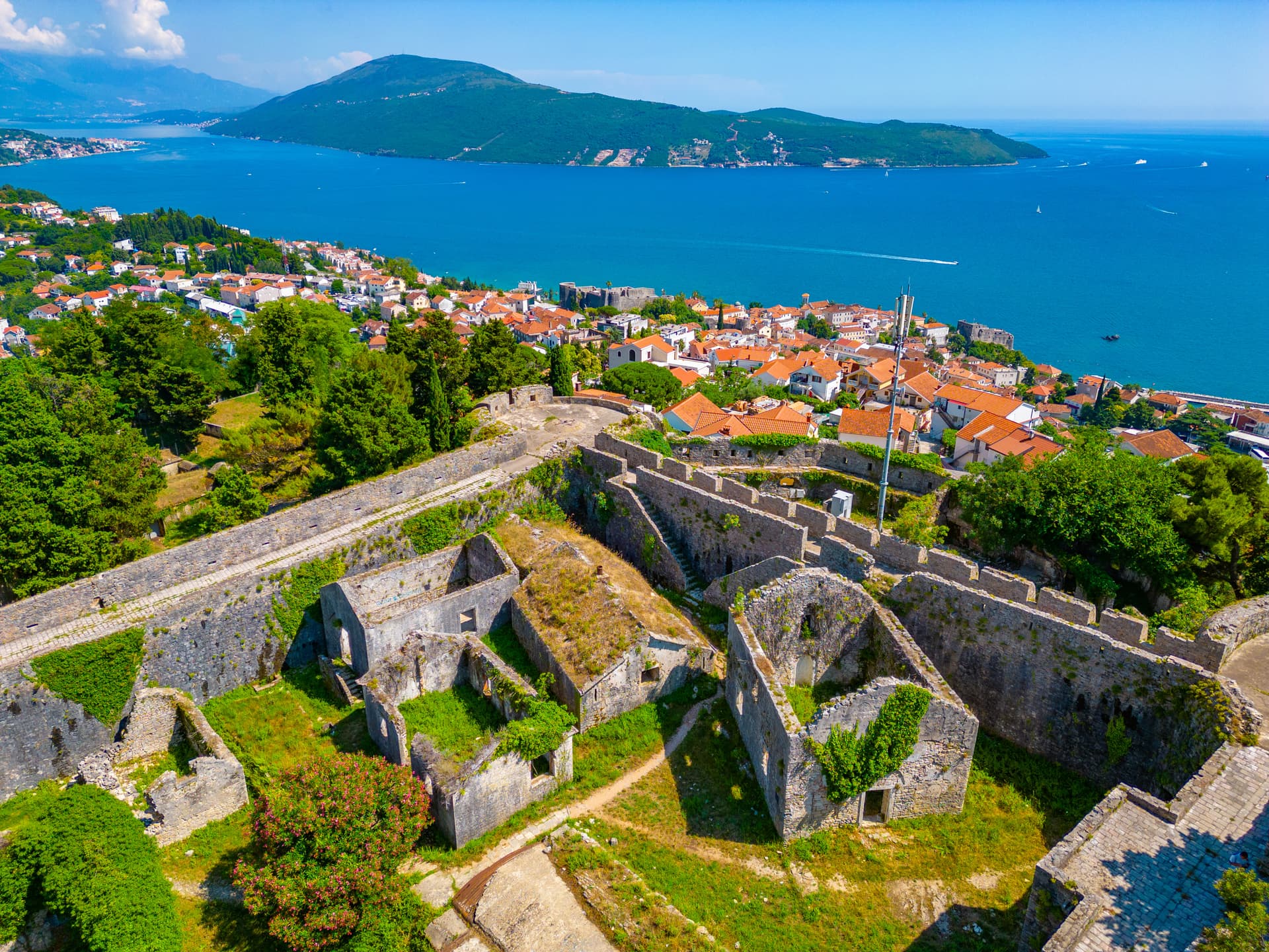 Herceg Novi Spanish fortress ruins overlooking the bright blue sea and coastal town in Montenegro.