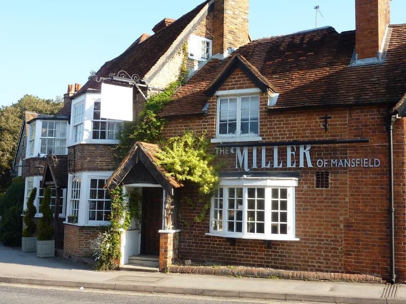 The Miller of Mansfield pub exterior with brick facade, white windows, and green ivy growth.