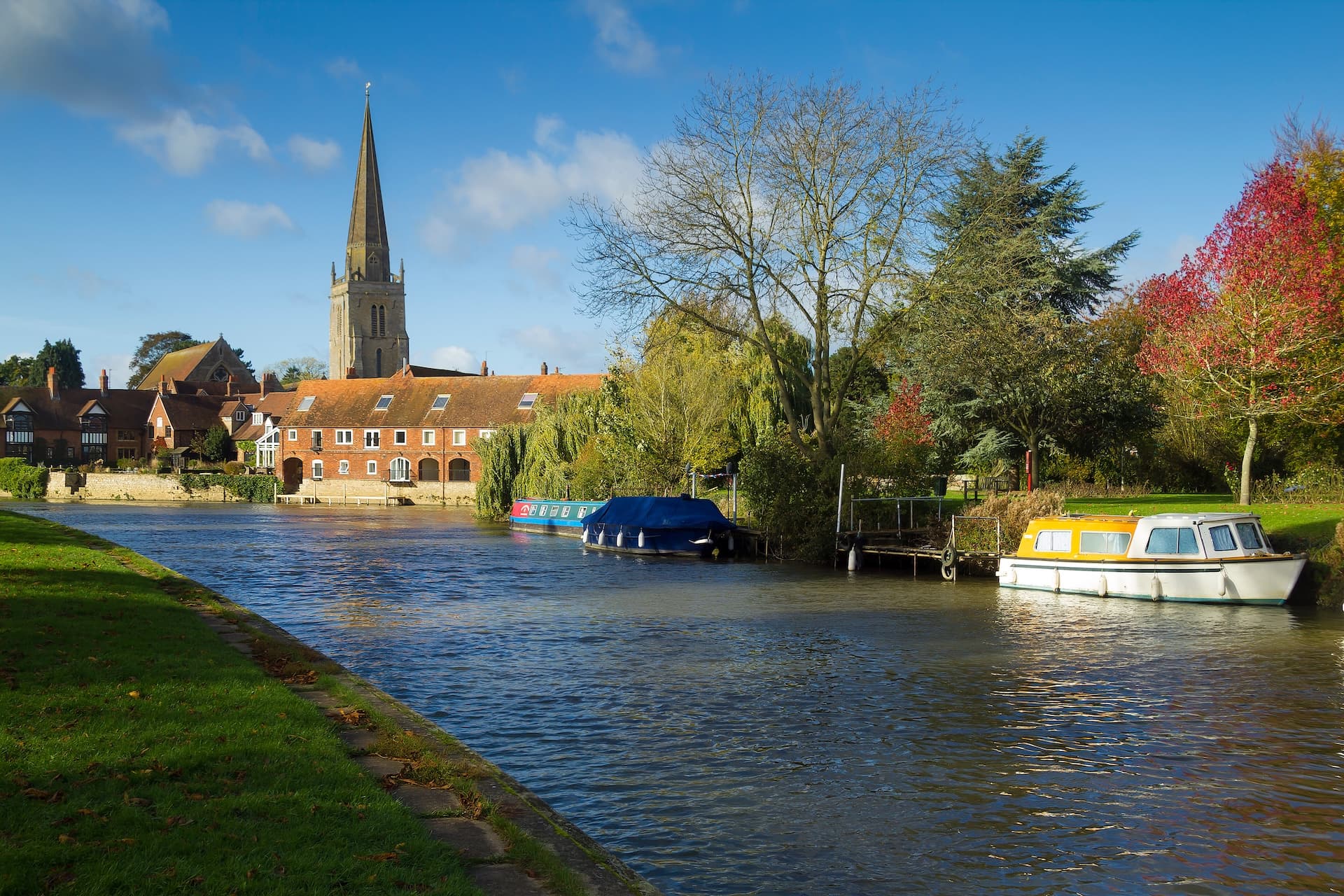 River scene with boats, a church spire, and autumn foliage in Abingdon.