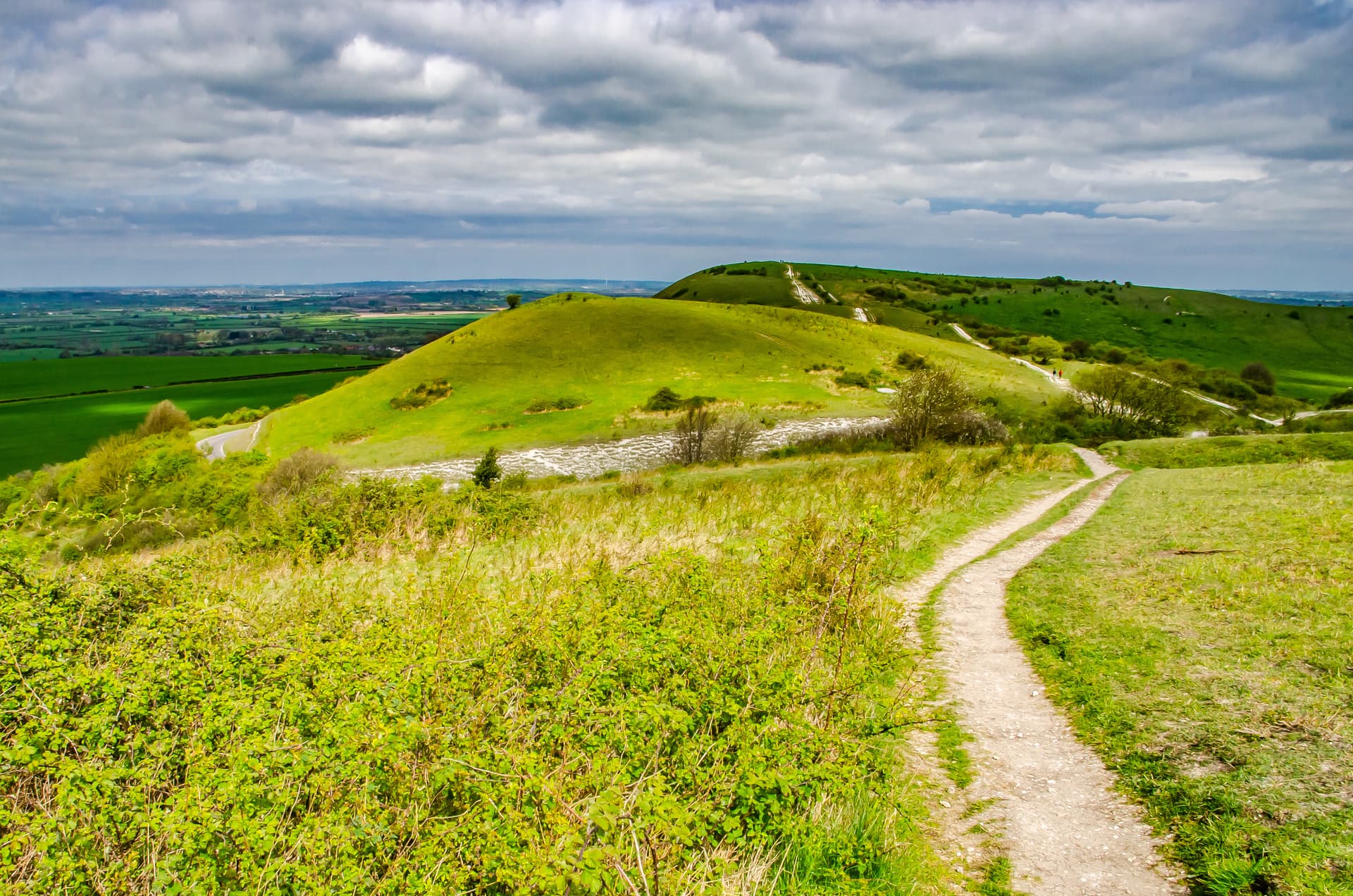 Hiking trail along rolling green hills under a cloudy sky in the Chiltern Hills.