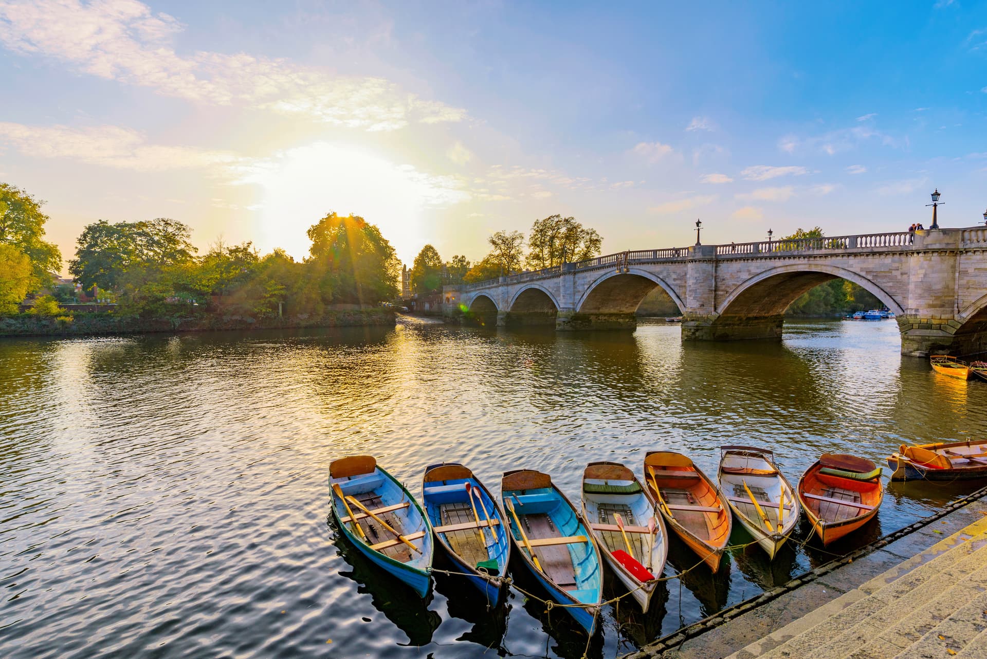 Rowboats moored by a stone bridge over a river at sunset, filename suggests Richmond.