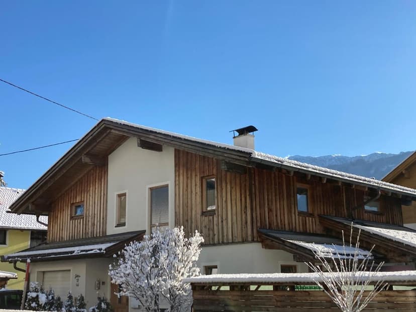 Vacation apartment in Waldheim with wood siding, snow, and mountains under blue sky