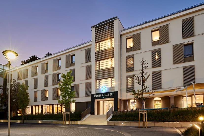 Hotel Adalbert building exterior at dusk with illuminated entrance and street lamp