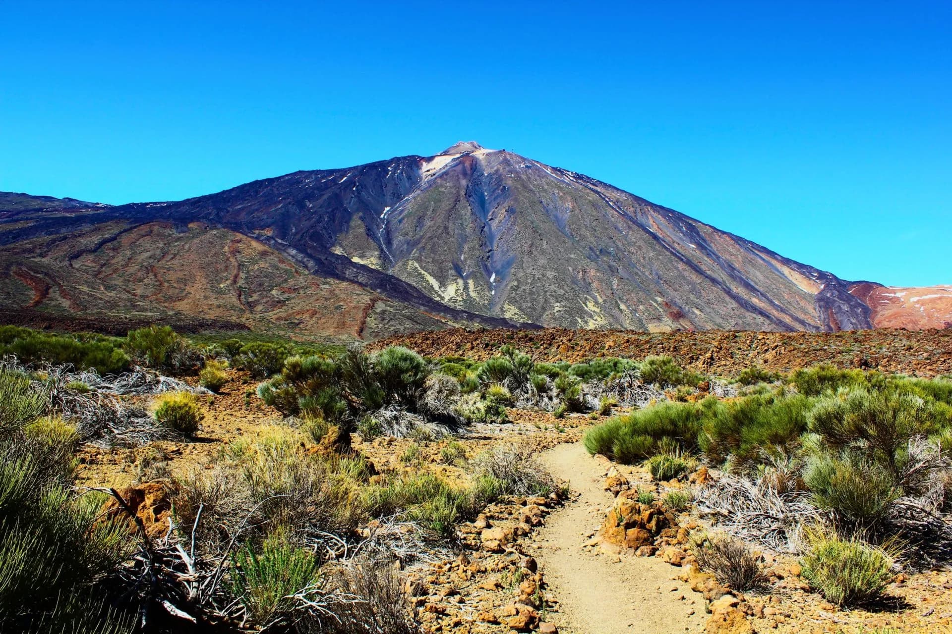 Hiking trail through arid scrubland toward Mount Teide volcano, Tenerife, Canary Islands.