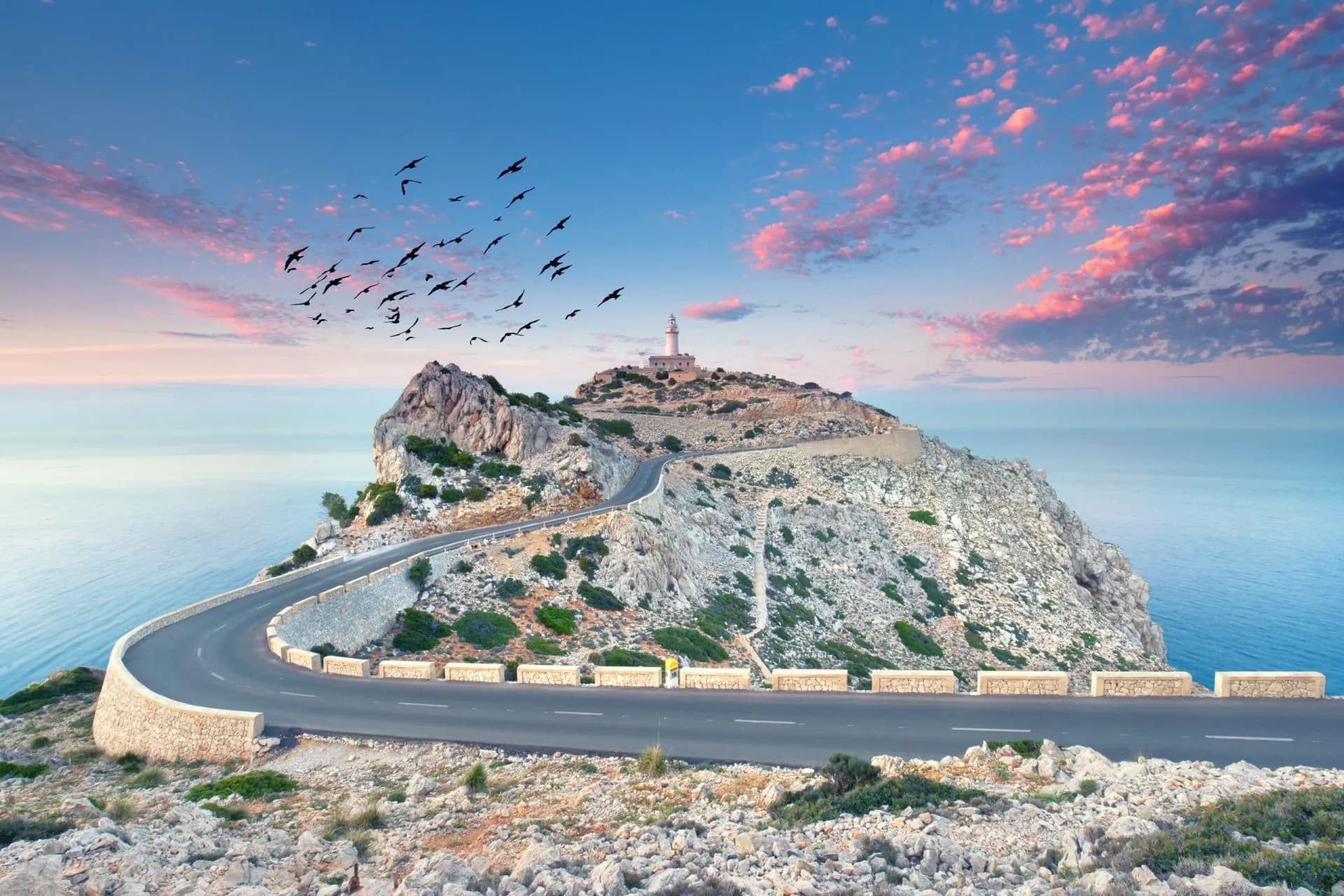 Winding road to lighthouse on rocky cliff overlooking the sea at Cap Formentor, Mallorca.