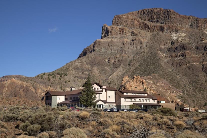 Parador de Las Cañadas del Teide hotel nestled at the base of a large, arid mountain.