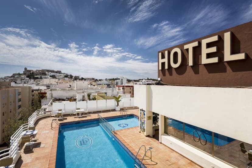 Rooftop pool area of Hotel Royal Plaza overlooking a white city and distant hill fort.