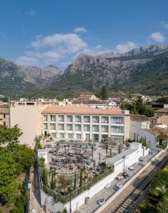 Hotel Alcázar in Sóller with outdoor terrace and Tramuntana mountains backdrop.