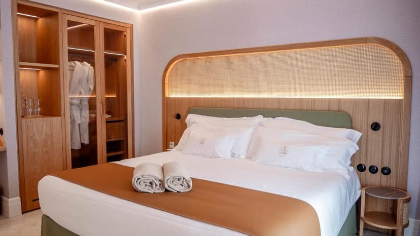 Hotel room with large bed, wooden headboard featuring cane webbing, and built-in wardrobe Alcázar Hotel Sóller.